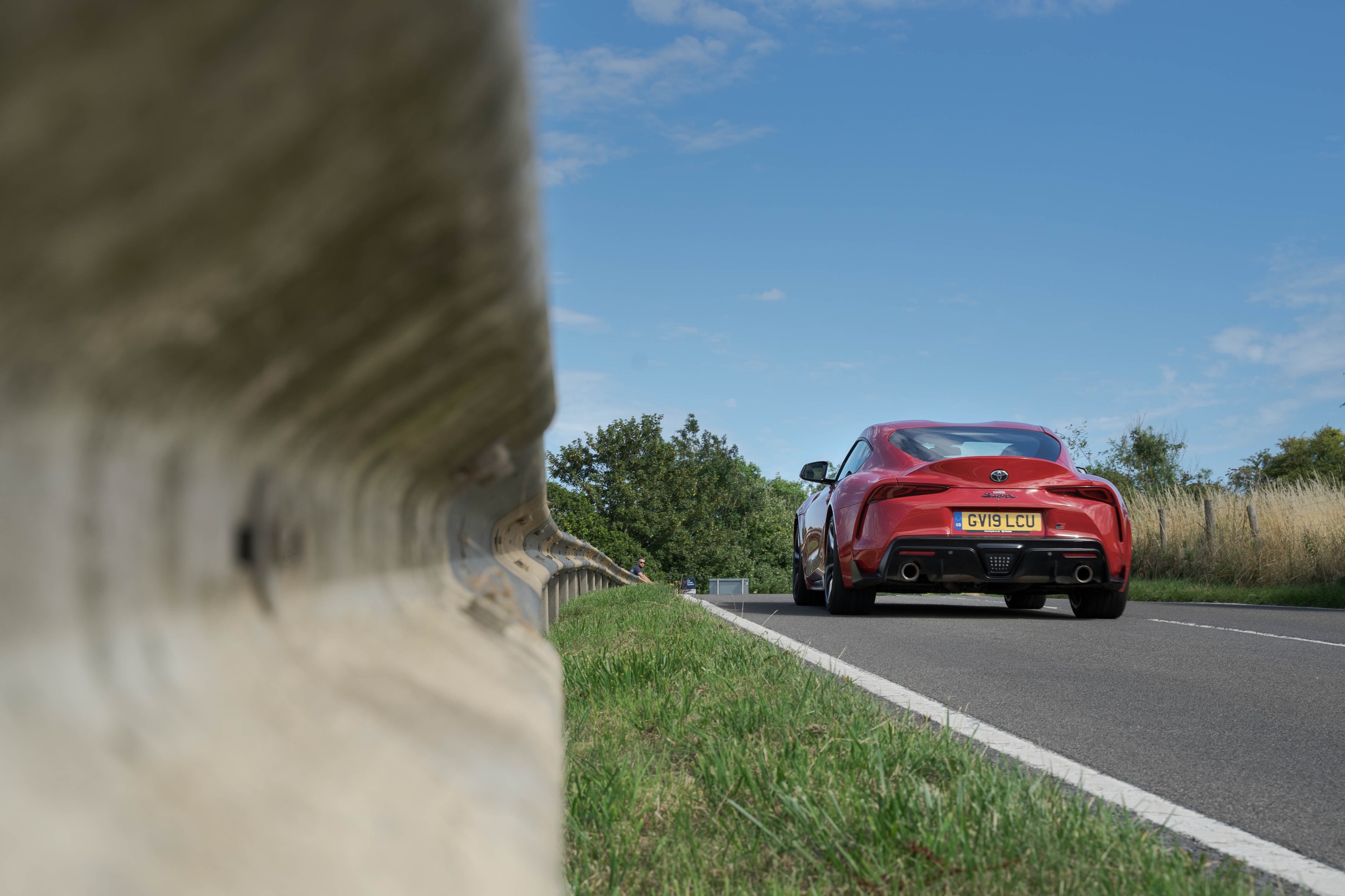 Toyota Supra driving on a road